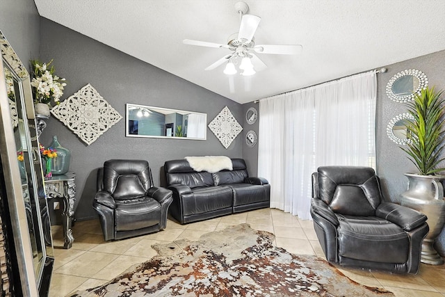 living room with ceiling fan, vaulted ceiling, and light tile patterned flooring