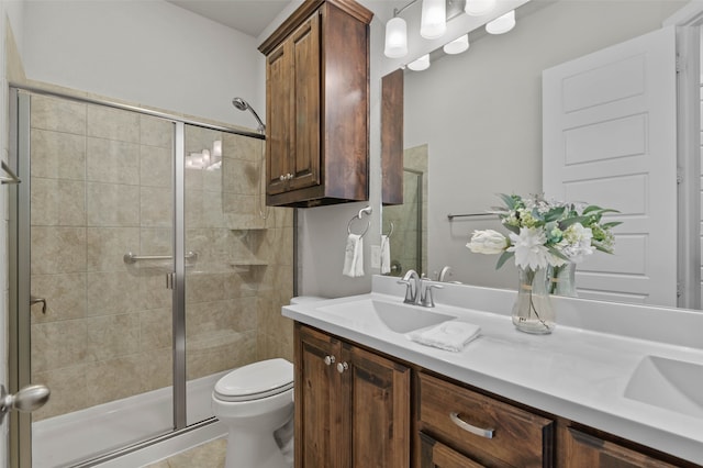 bathroom featuring vanity, toilet, a shower with shower door, and tile patterned flooring