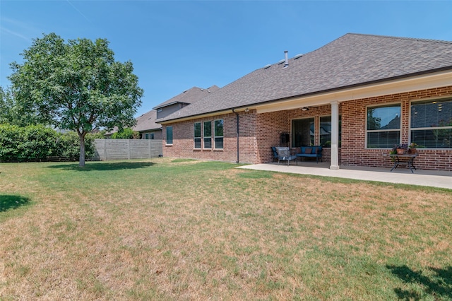 back of property featuring outdoor lounge area, a yard, and a patio area