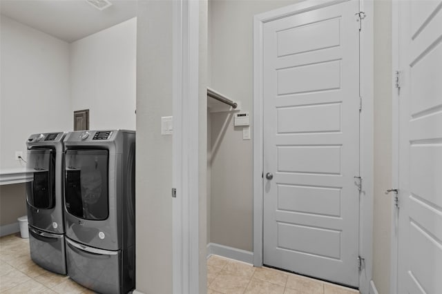 clothes washing area featuring separate washer and dryer and light tile patterned floors