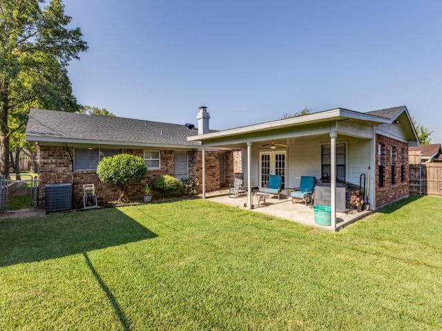 rear view of property with a lawn, a patio, and cooling unit