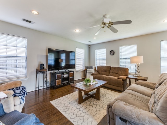 living room featuring dark wood-type flooring and ceiling fan