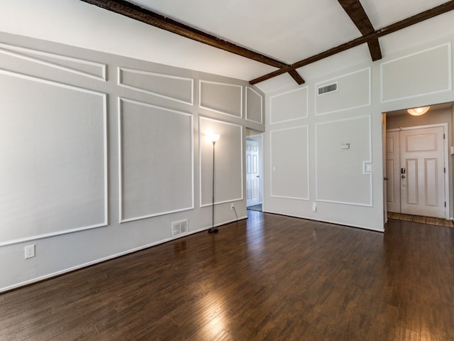 empty room featuring beam ceiling and dark hardwood / wood-style flooring