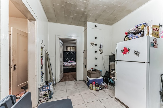 kitchen with light tile patterned flooring and white fridge