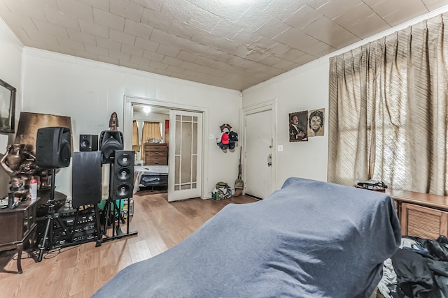 bedroom featuring crown molding, french doors, and light wood-type flooring