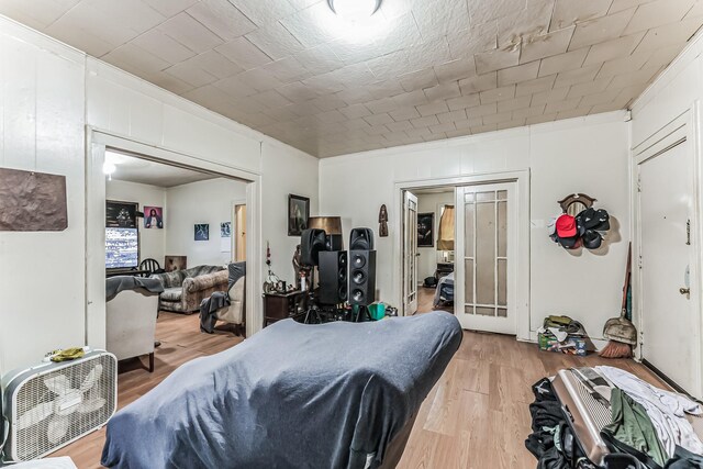 bedroom with ornamental molding and light hardwood / wood-style flooring