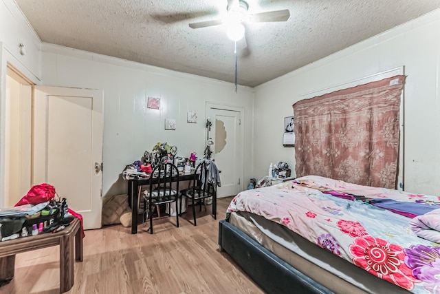 bedroom featuring ceiling fan, crown molding, light hardwood / wood-style flooring, and a textured ceiling