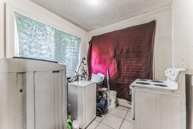 clothes washing area featuring hookup for a washing machine, a textured ceiling, and light tile patterned floors