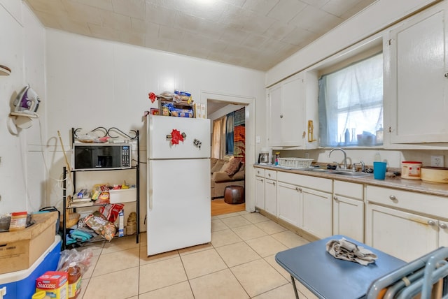 kitchen with white refrigerator, sink, and white cabinets