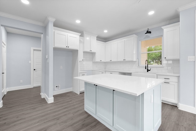 kitchen with a kitchen island, white cabinetry, sink, and dark wood-type flooring