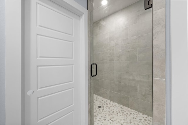 bathroom with a shower with door