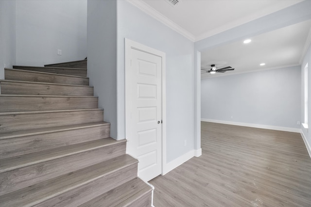 stairs featuring ornamental molding, hardwood / wood-style floors, and ceiling fan