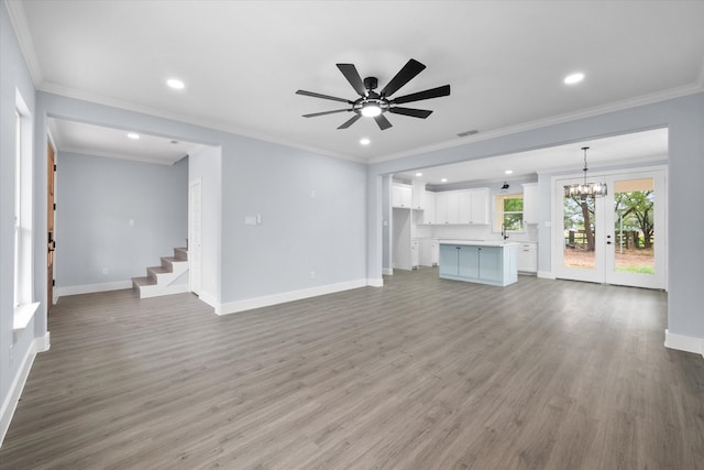 unfurnished living room with ceiling fan with notable chandelier, ornamental molding, hardwood / wood-style floors, and sink