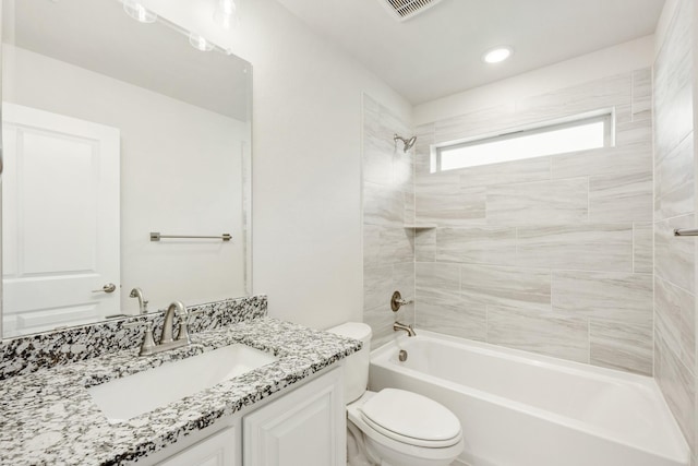 full bathroom with vanity, tiled shower / bath combo, and toilet