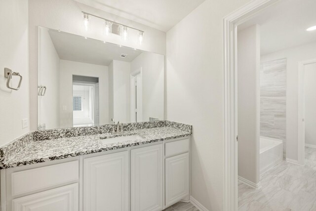 kitchen with lofted ceiling, white cabinetry, stainless steel oven, black microwave, and a kitchen island with sink