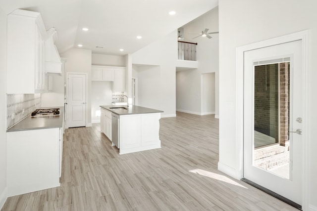 kitchen with stainless steel appliances, a kitchen island with sink, sink, and white cabinets