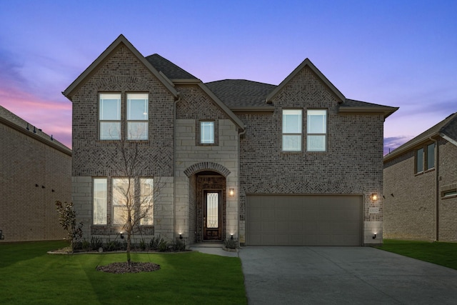 view of front of property featuring a garage and a yard