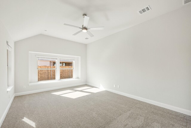 spare room with light colored carpet and vaulted ceiling