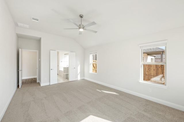 unfurnished bedroom with ensuite bathroom, lofted ceiling, light carpet, and ceiling fan