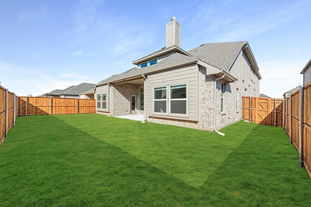 rear view of house featuring a yard and a patio area