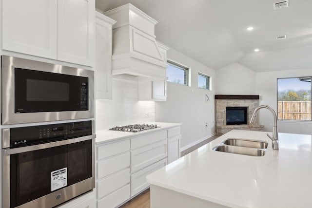 kitchen with sink, white cabinetry, stainless steel gas cooktop, a healthy amount of sunlight, and built in microwave