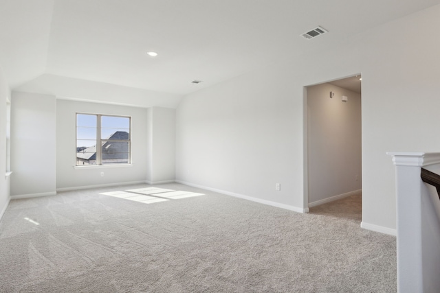 empty room with lofted ceiling and light carpet