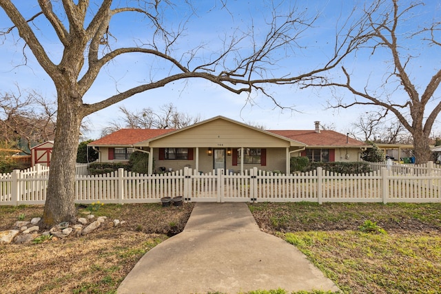 view of front of house with a fenced front yard, a gate, and brick siding