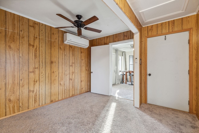 carpeted empty room featuring ceiling fan, wooden walls, and a wall unit AC