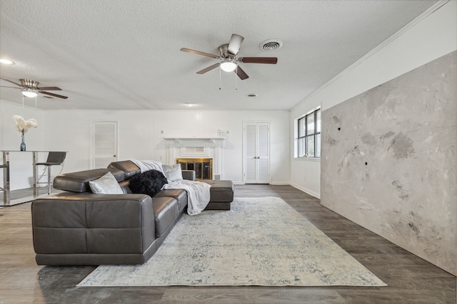 living room with a textured ceiling, ceiling fan, and hardwood / wood-style flooring