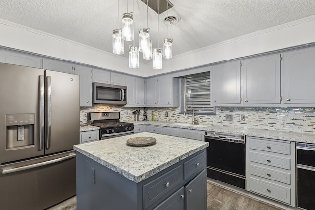 kitchen with sink, backsplash, appliances with stainless steel finishes, and a center island