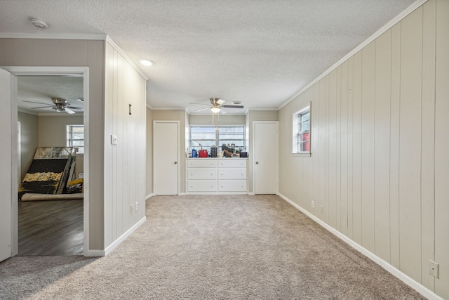 interior space featuring ceiling fan, carpet, and crown molding