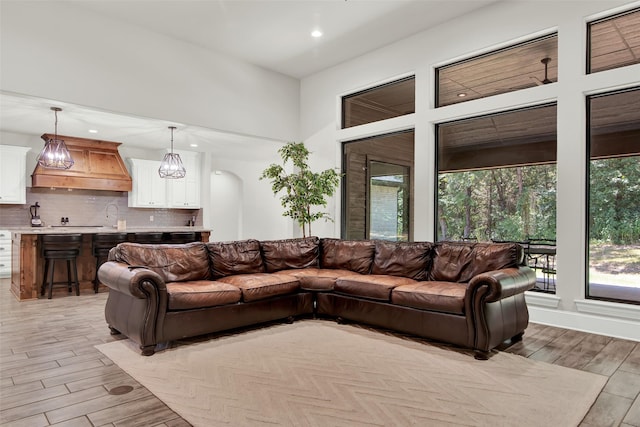 living room featuring recessed lighting, arched walkways, and light wood finished floors