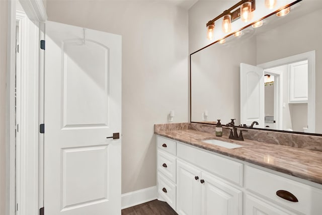 bathroom featuring baseboards, wood finished floors, and vanity