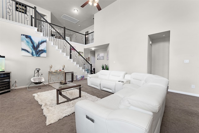 living room featuring carpet flooring, ceiling fan, and a high ceiling