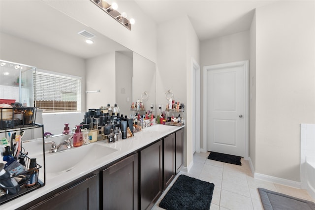 bathroom featuring a bath, tile patterned flooring, and double sink vanity