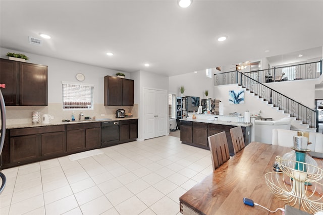 kitchen with dark brown cabinets, decorative backsplash, sink, black dishwasher, and light tile patterned floors