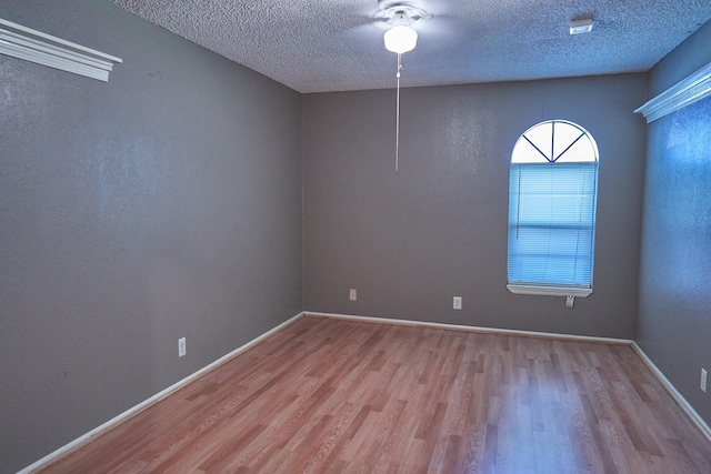 spare room with light hardwood / wood-style floors, ceiling fan, and a textured ceiling