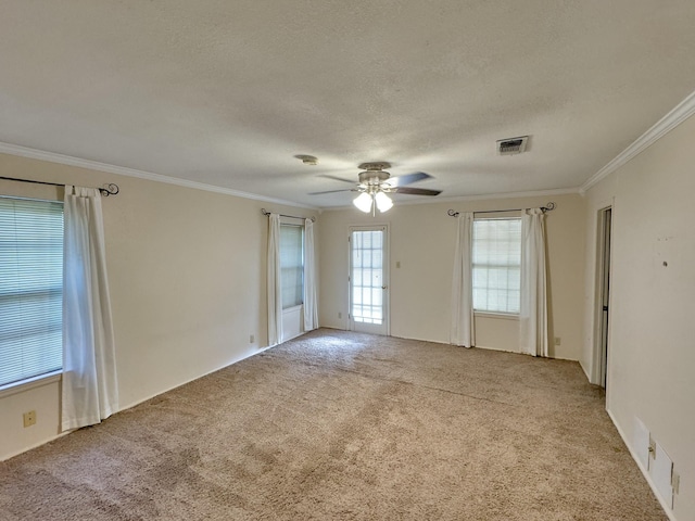 carpeted empty room with ceiling fan, crown molding, and a textured ceiling