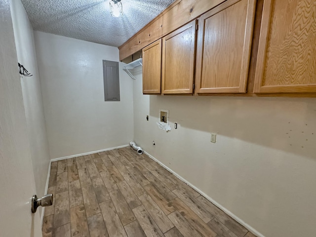 clothes washing area with cabinets, hookup for an electric dryer, electric panel, light hardwood / wood-style floors, and washer hookup