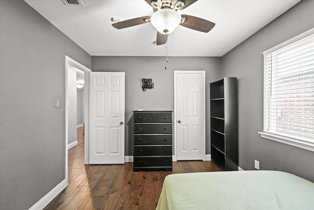 bedroom with ceiling fan and dark wood-type flooring