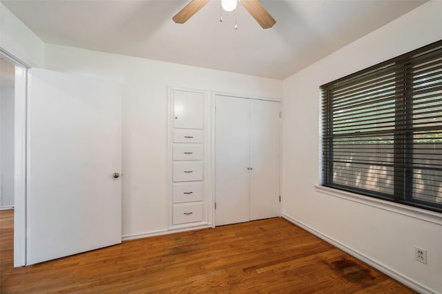 unfurnished bedroom with a closet, hardwood / wood-style floors, and ceiling fan