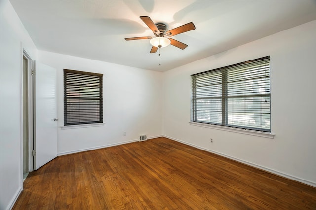 unfurnished room with ceiling fan and dark wood-type flooring