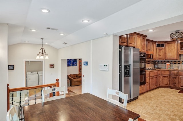 kitchen featuring light parquet floors, independent washer and dryer, stainless steel appliances, decorative backsplash, and vaulted ceiling