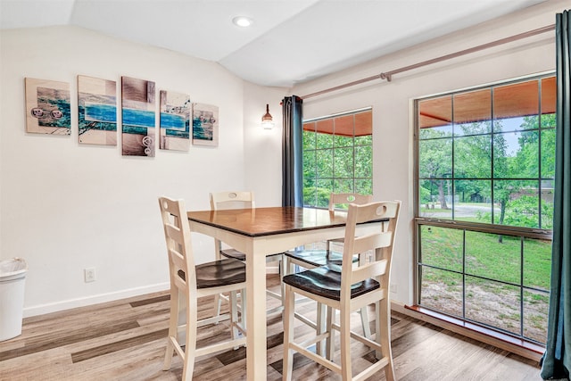 dining space featuring hardwood / wood-style flooring and vaulted ceiling