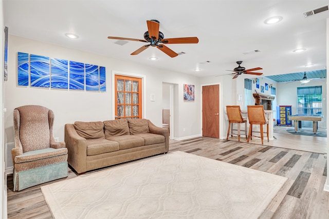 living room featuring light wood-type flooring and ceiling fan