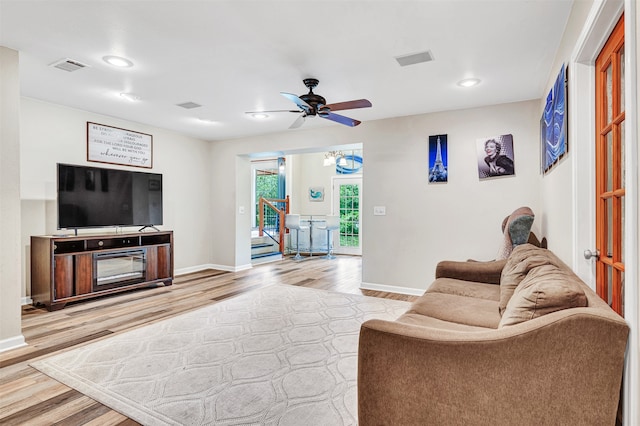 living room with light hardwood / wood-style flooring and ceiling fan