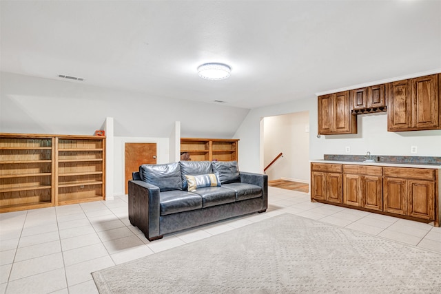 living room featuring sink and light tile patterned flooring