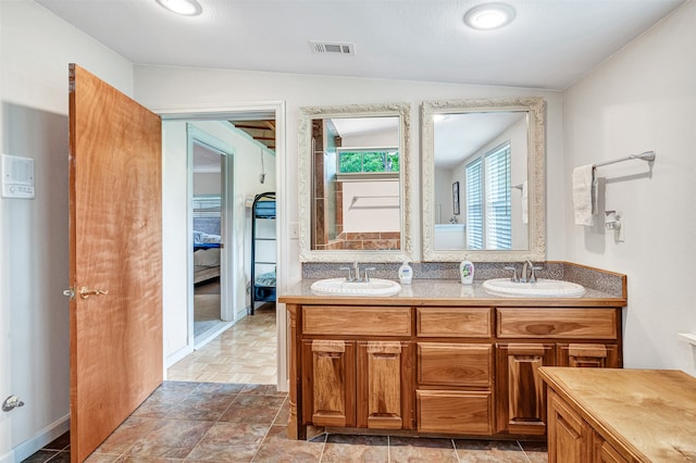 bathroom with lofted ceiling, tile patterned floors, and dual bowl vanity