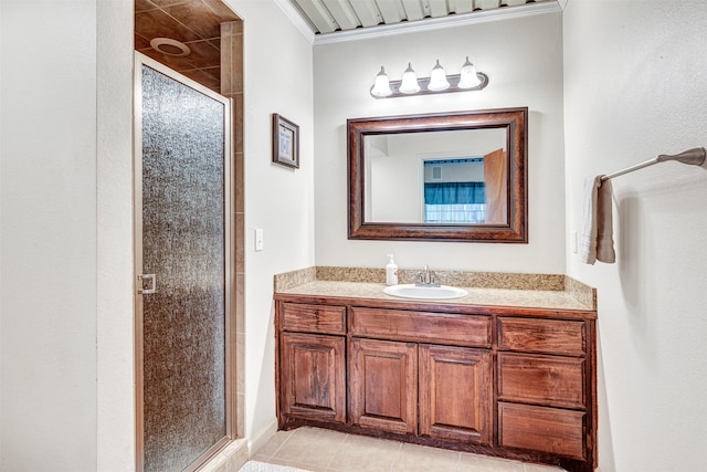 bathroom featuring tile patterned floors, a shower with shower door, crown molding, and vanity