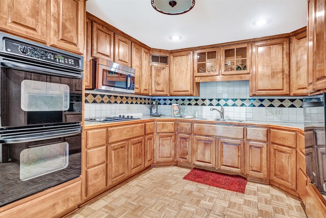 kitchen with tile countertops, tasteful backsplash, light parquet flooring, and stainless steel appliances